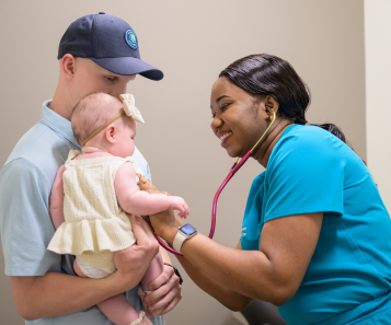 Doctor-examining-baby.held-by-Dad